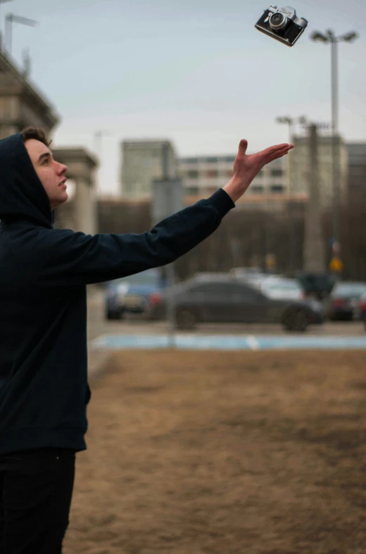 a man in a black hoodie trying to get a flying disc