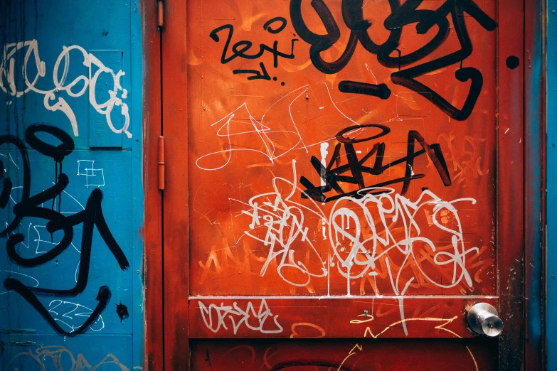 a door covered in graffiti sitting under a blue sky