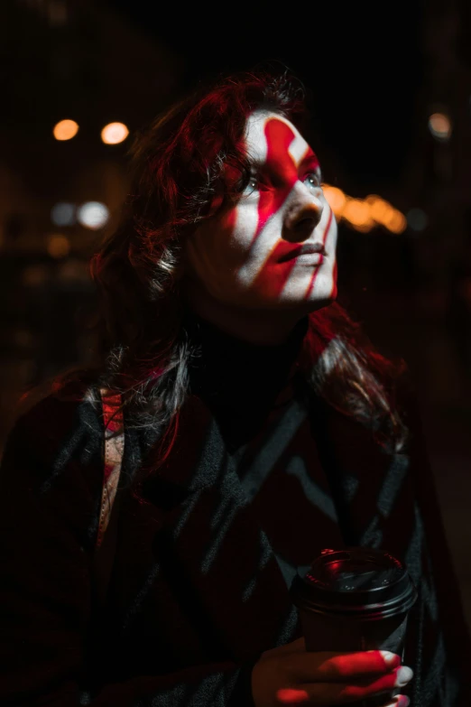 a woman with painted face holding a cup of coffee