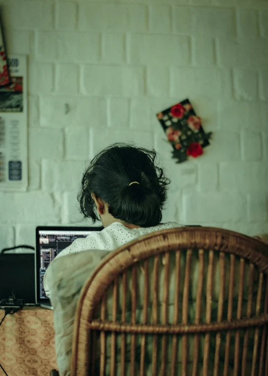 a woman sitting at a desk with a laptop in front of her