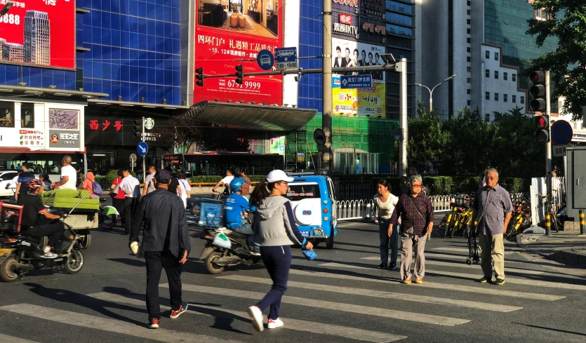 people walk on the street in front of tall buildings