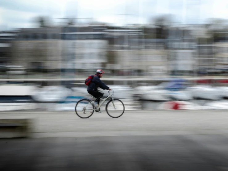 a blurry po shows a man riding his bicycle