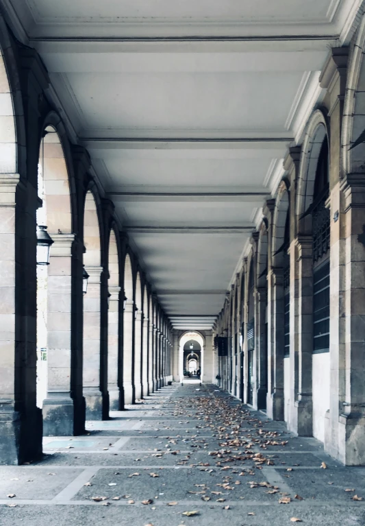 a walkway lined with columns under lots of light
