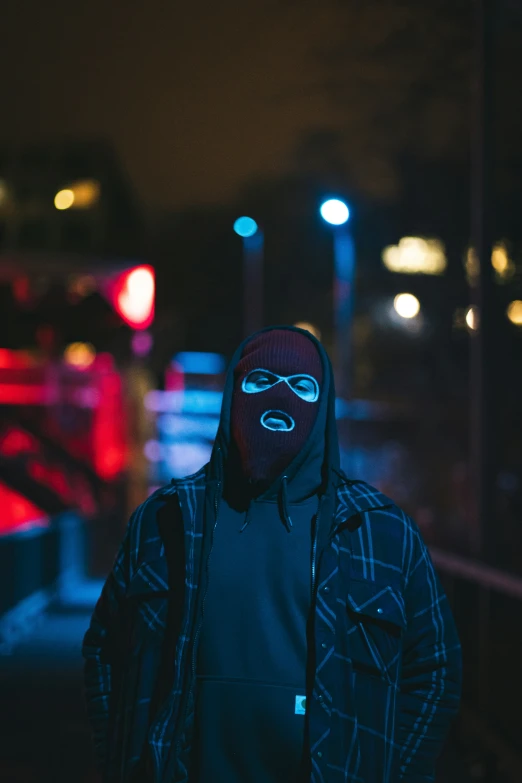 a person wearing a mask standing outside in the night
