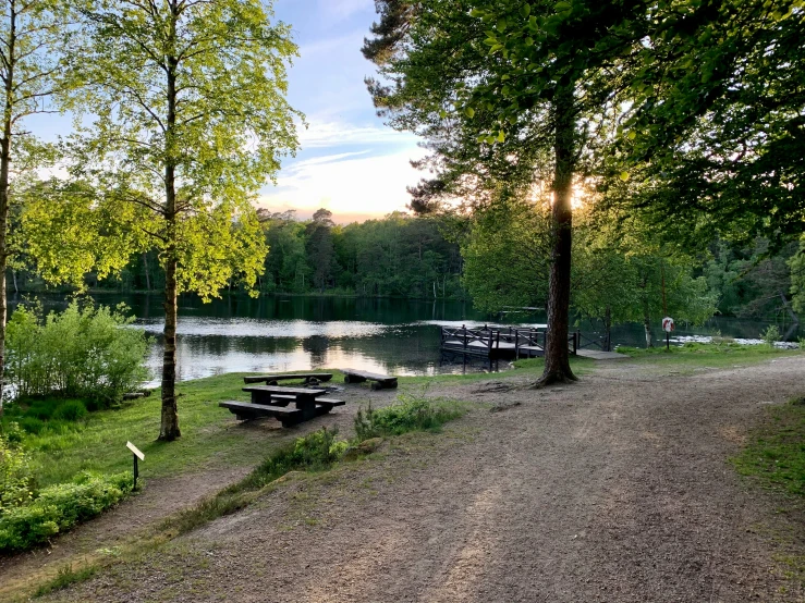 some picnic tables in front of a lake