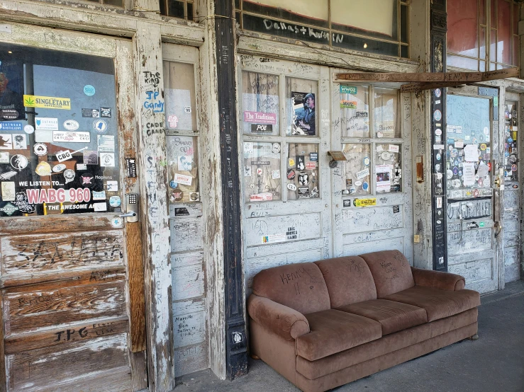 an old couch and wooden cabinet outside of a room