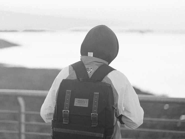 a man wearing a back pack on top of a hill