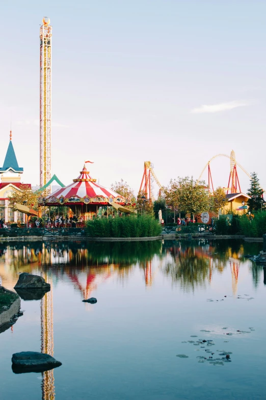 ferris wheel and water park reflected on clear pond