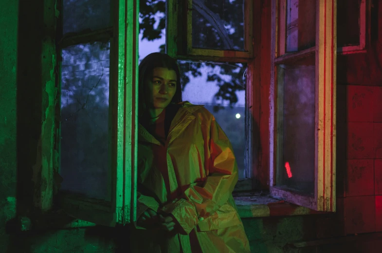 a woman in raincoat standing in window