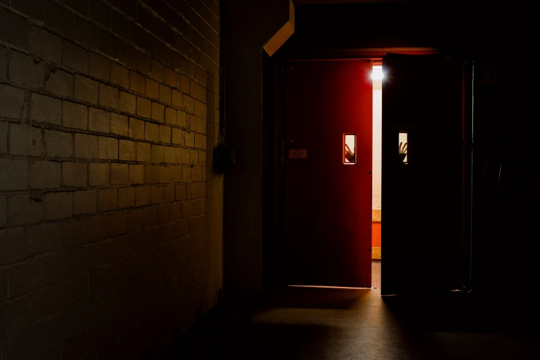 a hallway in the dark with an open door