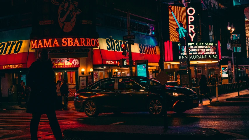 a dark city street at night with a neon sign for the mama sahara in new york