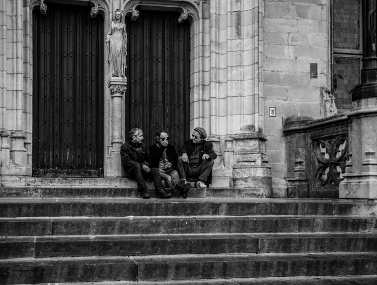 black and white pograph of two people sitting on steps