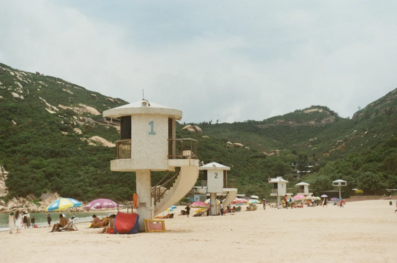 a large sculpture sits on a beach next to a mountain