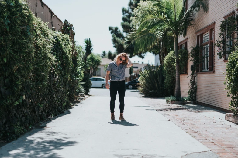 a woman walking down the middle of a small alley way