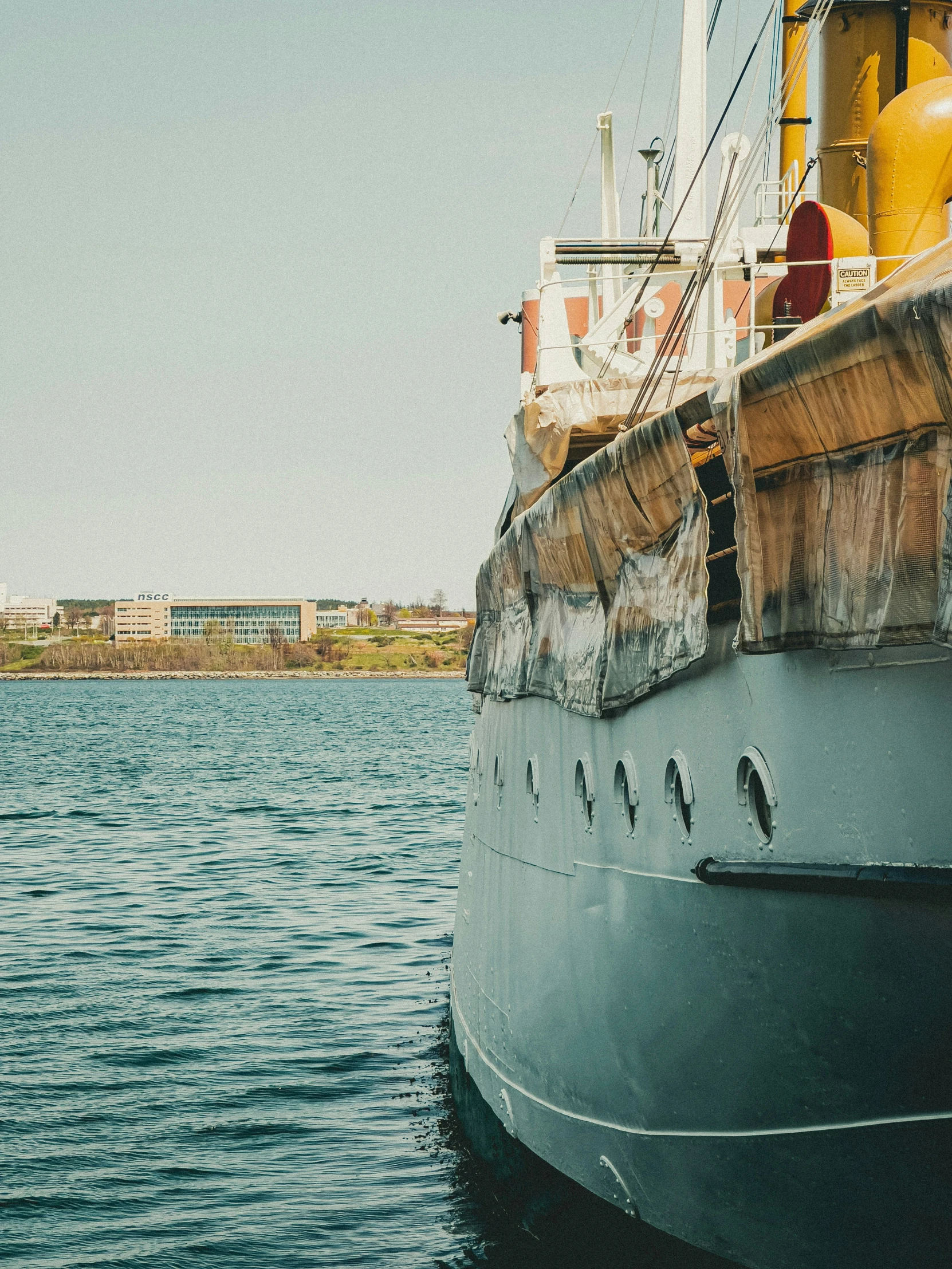 a large ship in the water next to shore