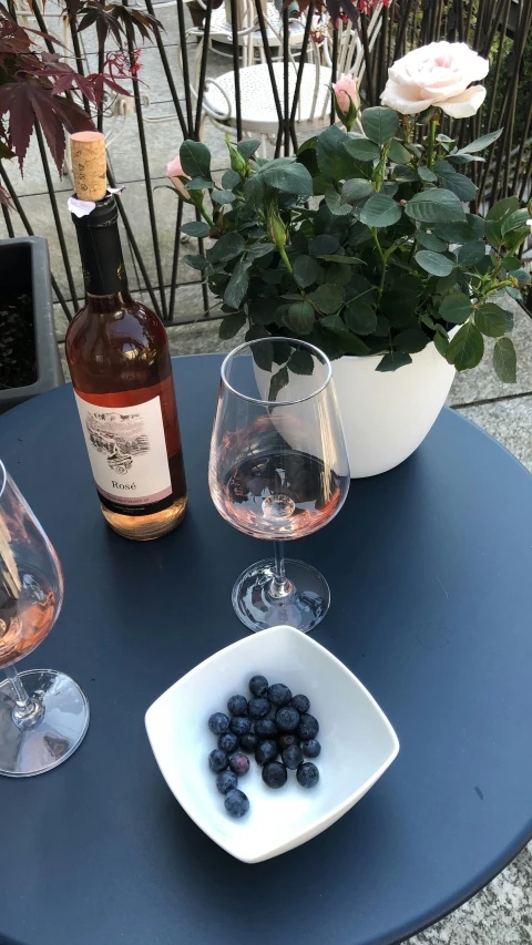 two glasses, a bottle and an empty wine glass on the table