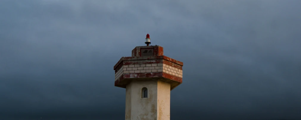 a red and white tower on a stormy day