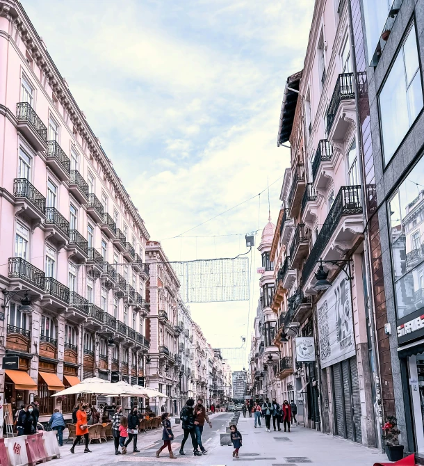 many people are walking on the sidewalk of the city