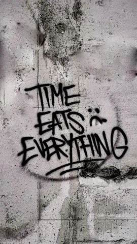graffiti painted on the wall of an alleyway reads time eats everywhere