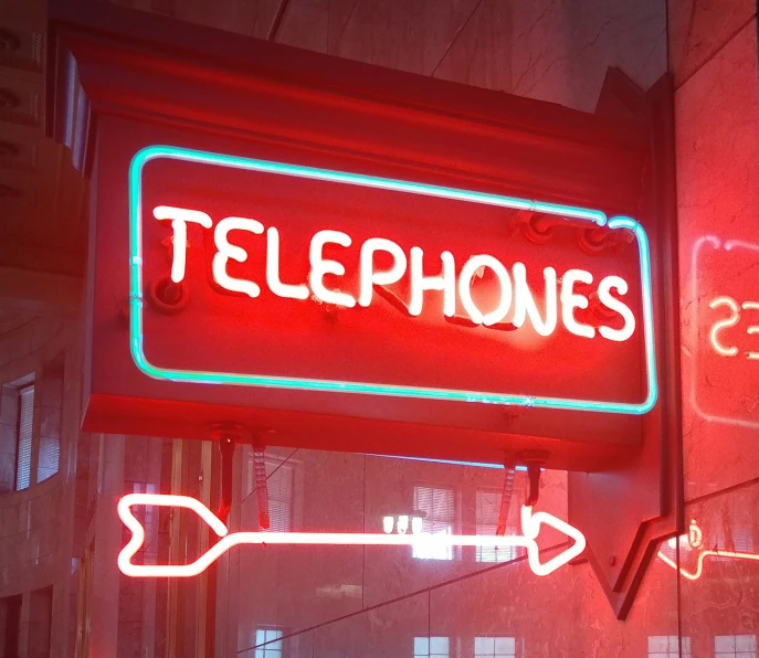 a large neon sign hangs on the side of a building