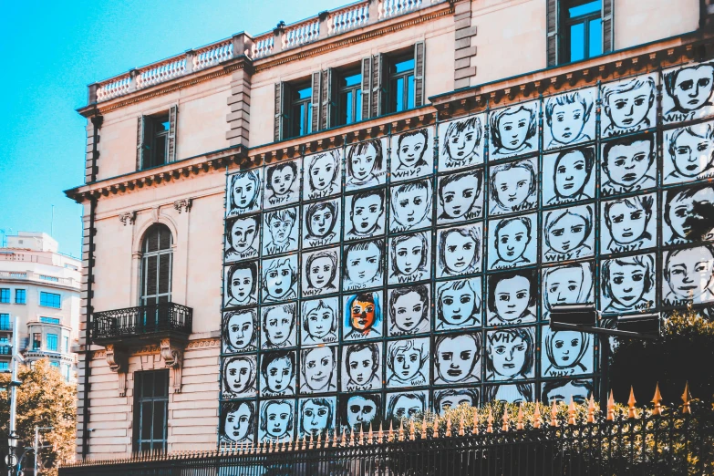 the side of an old building with skulls and faces on it
