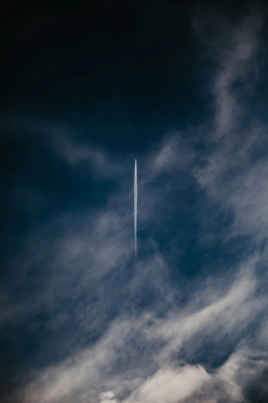 a plane flies through the cloudy sky