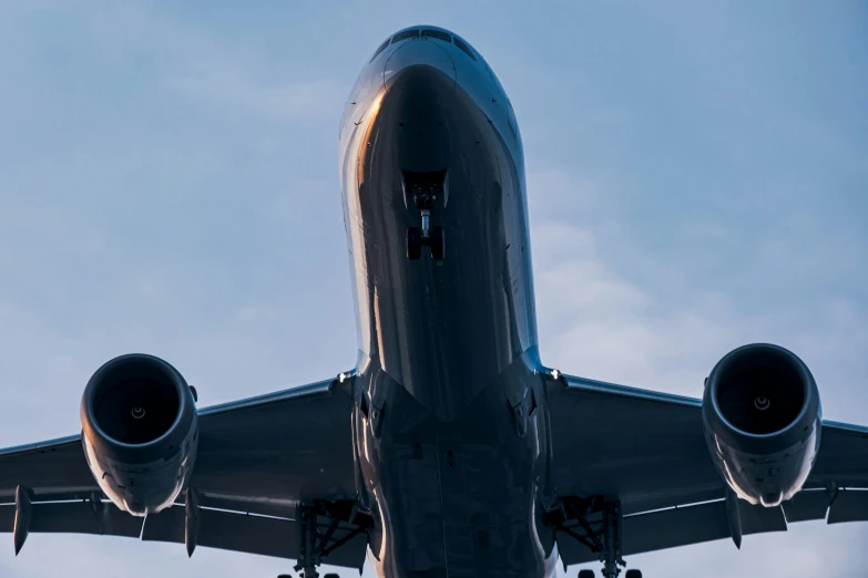 an airplane flies through the sky with landing gear down