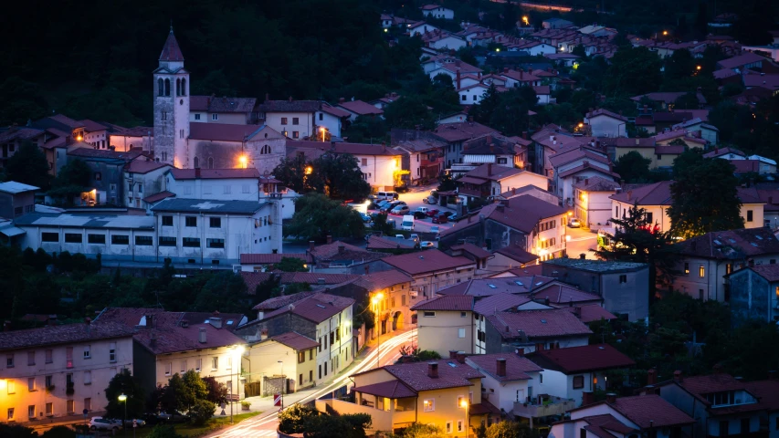 a city with red roofs is illuminated at night