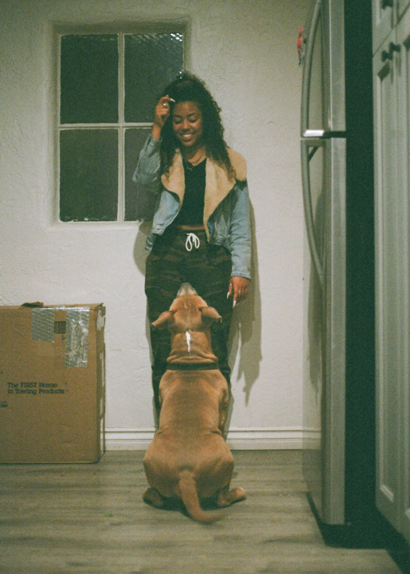 a  in the kitchen playing with her dog