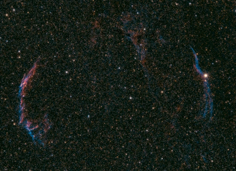 two stars and two rings in the center of a dark sky