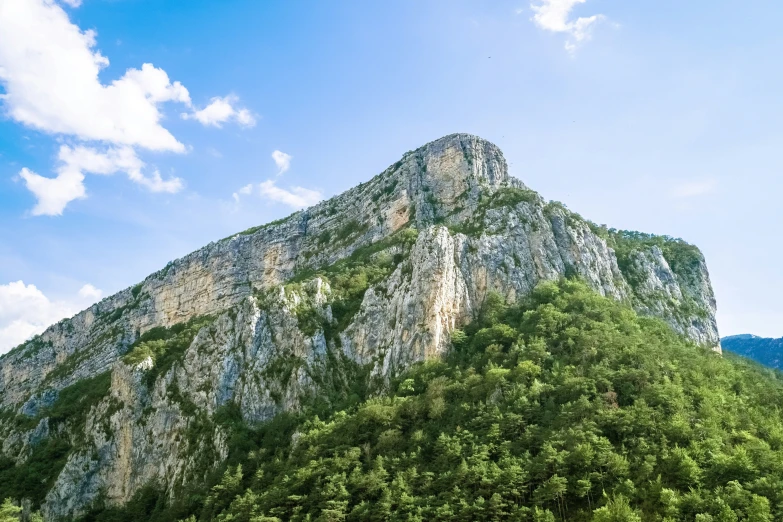 a mountain top rises to the sky in a wooded area