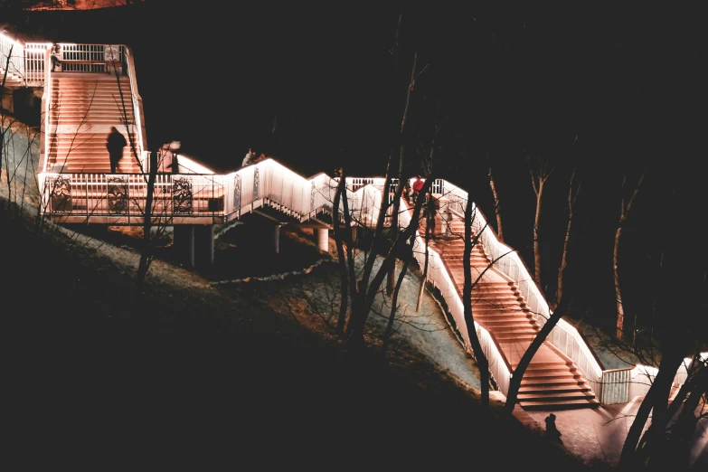 people walking along a walkway near a railing and some trees