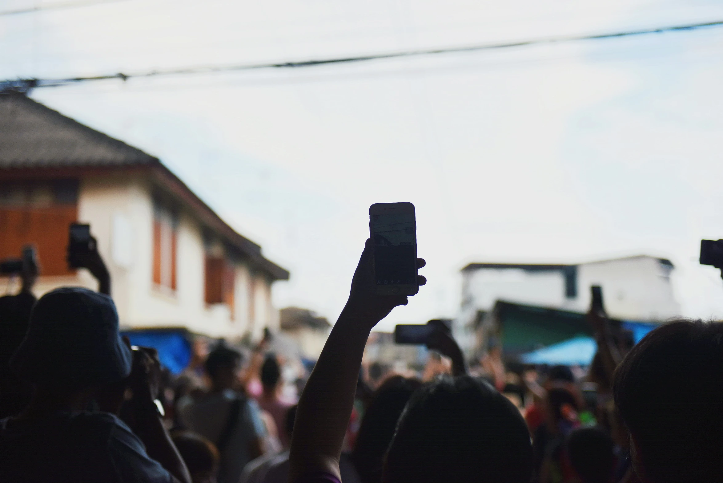 a crowd of people looking at their phones with a person on a cell phone