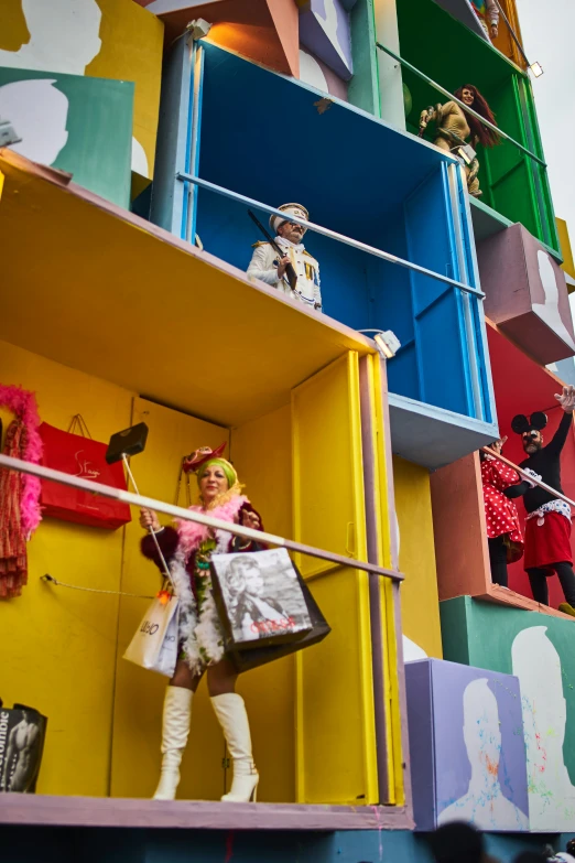 a woman in white holding a handbag outside of a multi - colored building