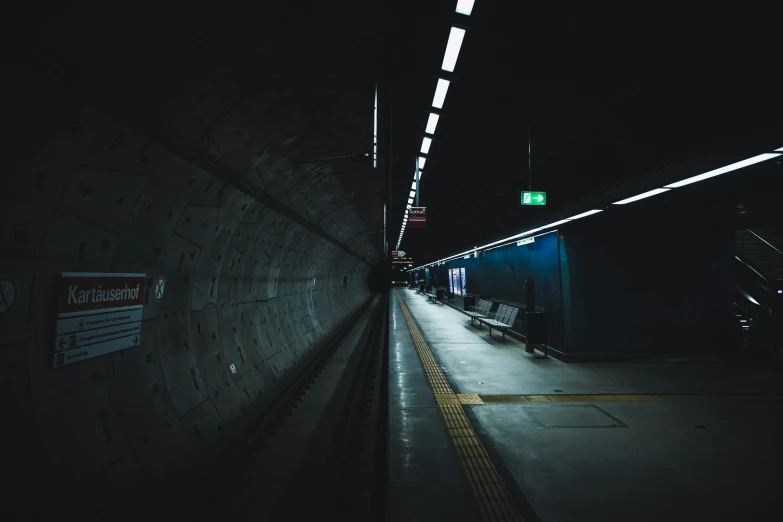 a subway with dark lighting and signs on the wall