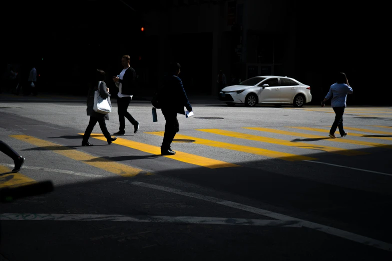 pedestrians cross an intersection in the dark on the street