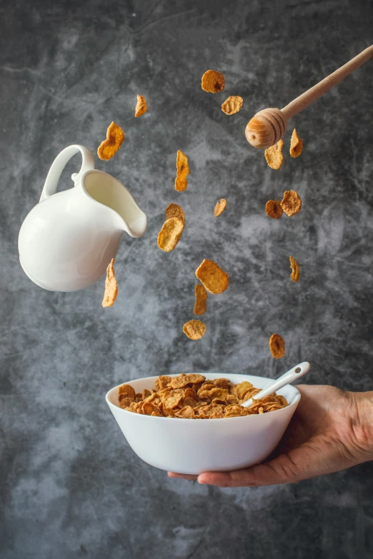 this is someone's hands and cereal that is falling