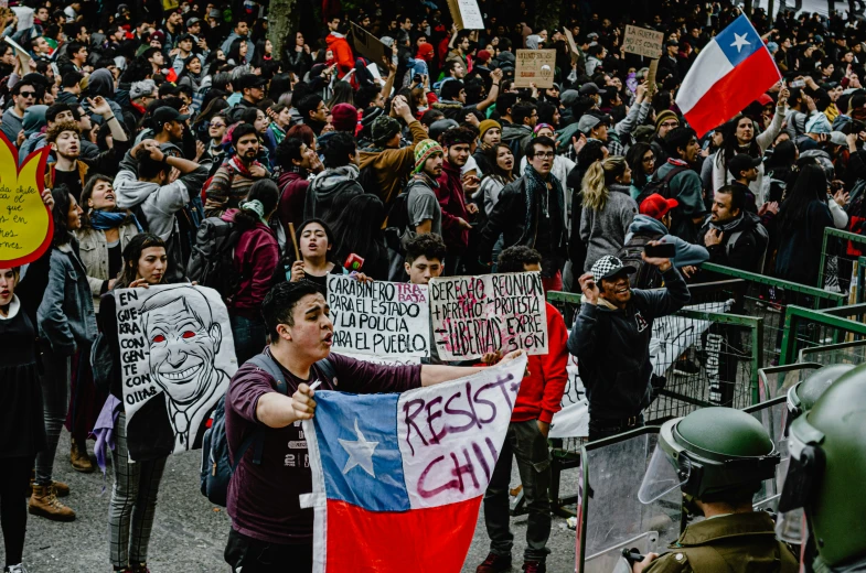 several people standing around each other holding flags and signs