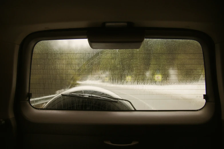 the view from inside of a vehicle of a road and rain