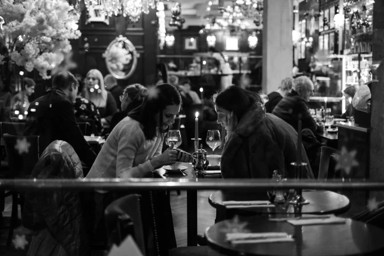 black and white image of a restaurant full of people