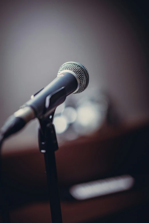 a black microphone in front of a wooden table