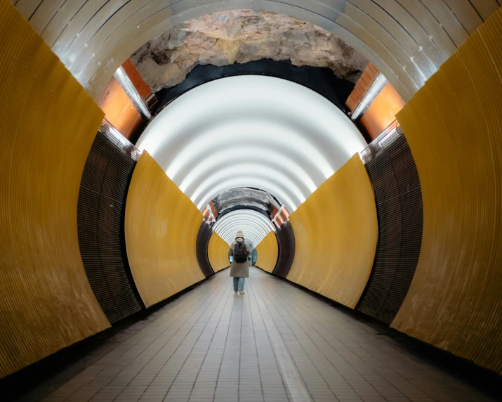a person is standing in a long tunnel