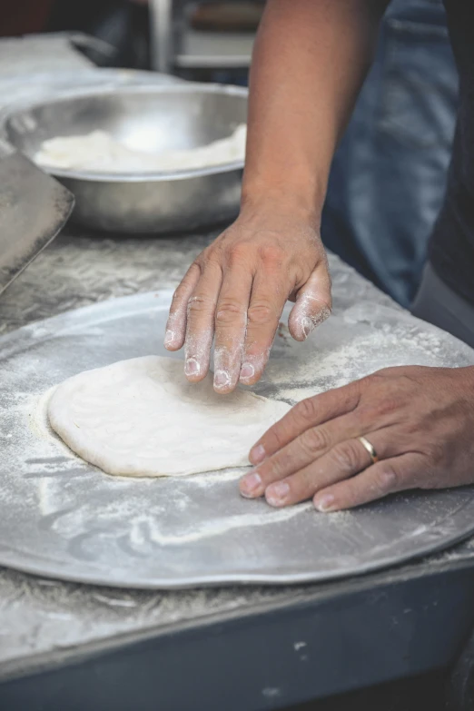 a person's hand making food on top of a stove