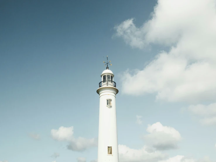 an ocean side view of a lighthouse near the ocean