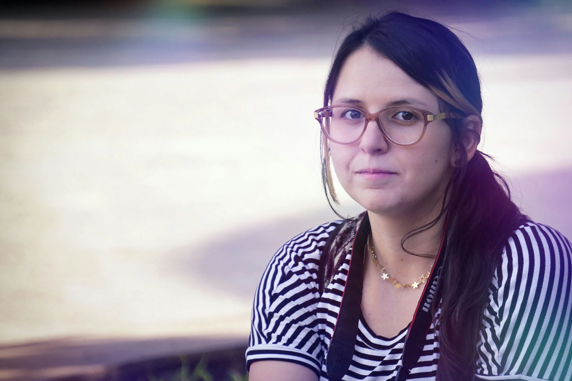 a girl wearing glasses poses for a po