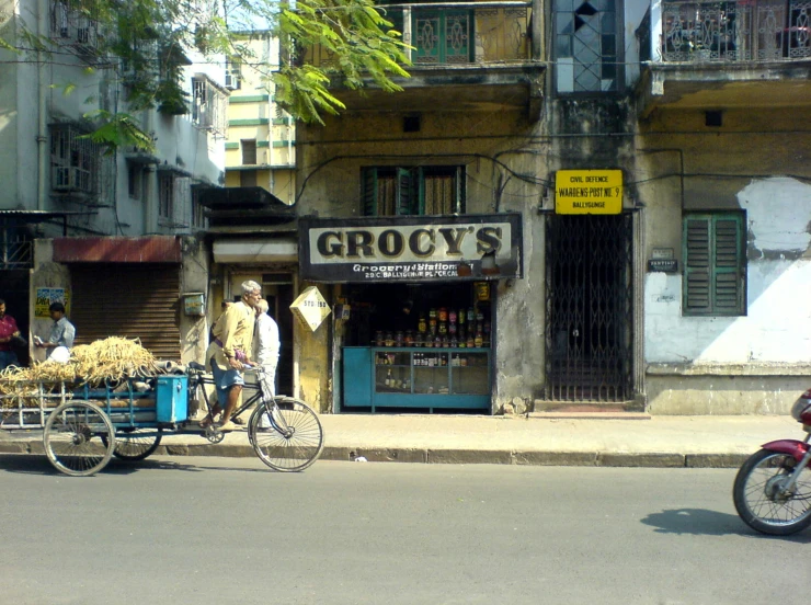 a man riding on a bicycle next to another man with a bike