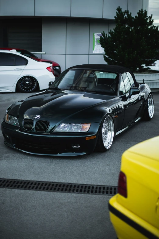 a black bmw m coupe with white wheels in parking lot