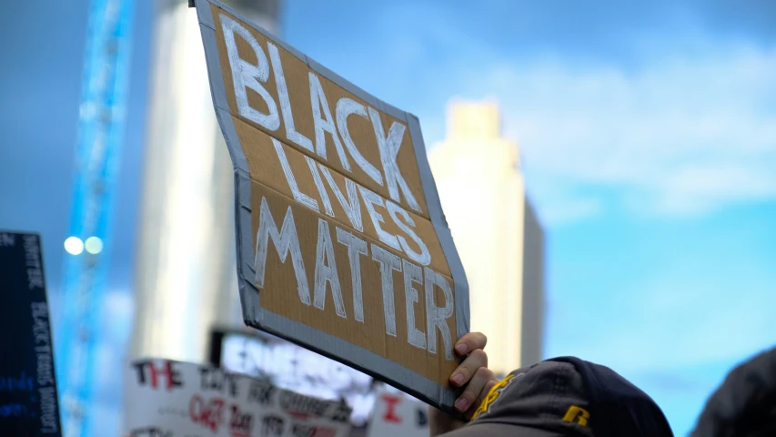 some people hold up signs and stand near the city