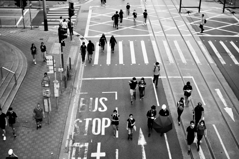 people walking along a street with a large message painted on it