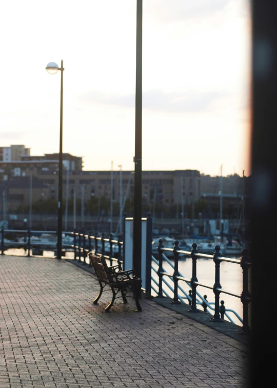 a park bench sitting next to a railing next to a body of water